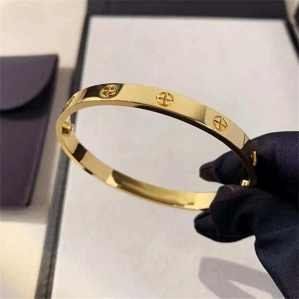 Pulsera y brazalete contemporáneo de cruz con clavo tipo tuerca en zirconia dorada 2023 para mujer en acero inoxidable.