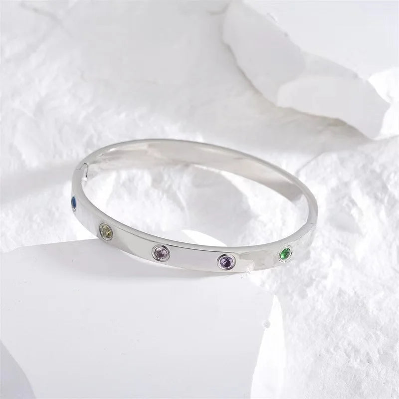 Pulsera y brazalete contemporáneo de cruz con clavo tipo tuerca en zirconia dorada 2023 para mujer en acero inoxidable.