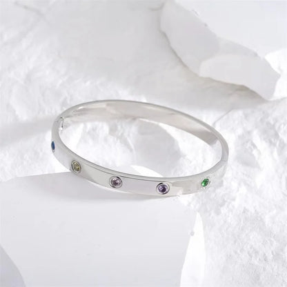 Pulsera y brazalete contemporáneo de cruz con clavo tipo tuerca en zirconia dorada 2023 para mujer en acero inoxidable.