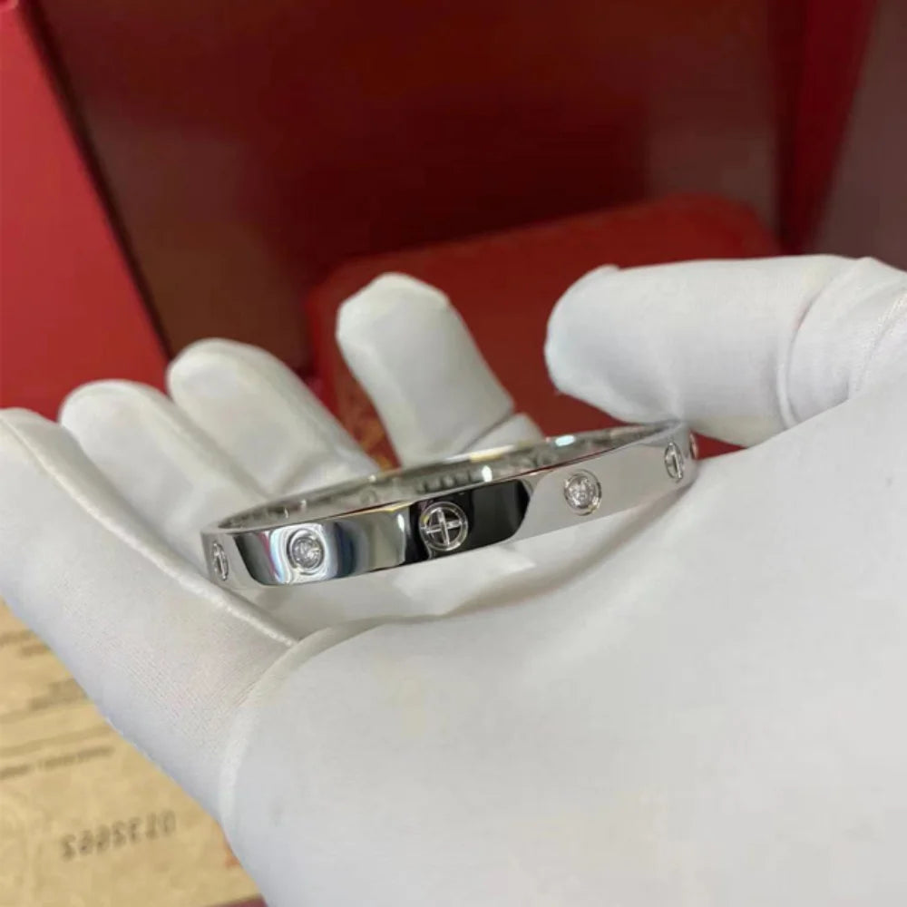 Pulsera y brazalete contemporáneo de cruz con clavo tipo tuerca en zirconia dorada 2023 para mujer en acero inoxidable.