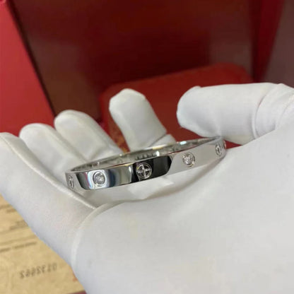 Pulsera y brazalete contemporáneo de cruz con clavo tipo tuerca en zirconia dorada 2023 para mujer en acero inoxidable.