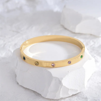 Pulsera y brazalete contemporáneo de cruz con clavo tipo tuerca en zirconia dorada 2023 para mujer en acero inoxidable.