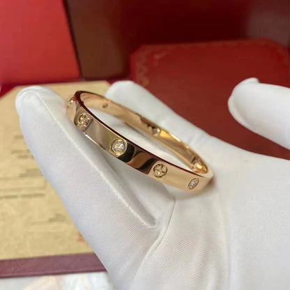 Pulsera y brazalete contemporáneo de cruz con clavo tipo tuerca en zirconia dorada 2023 para mujer en acero inoxidable.