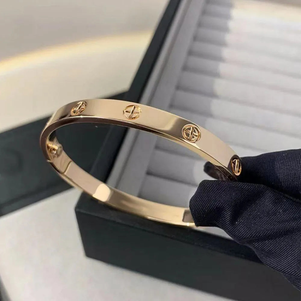 Pulsera y brazalete contemporáneo de cruz con clavo tipo tuerca en zirconia dorada 2023 para mujer en acero inoxidable.