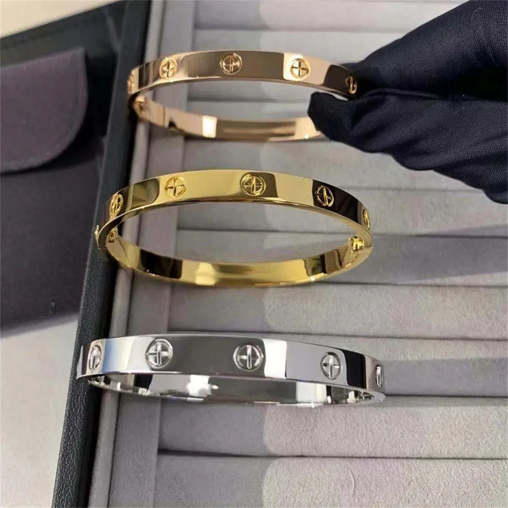 Pulsera y brazalete contemporáneo de cruz con clavo tipo tuerca en zirconia dorada 2023 para mujer en acero inoxidable.