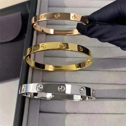 Pulsera y brazalete contemporáneo de cruz con clavo tipo tuerca en zirconia dorada 2023 para mujer en acero inoxidable.